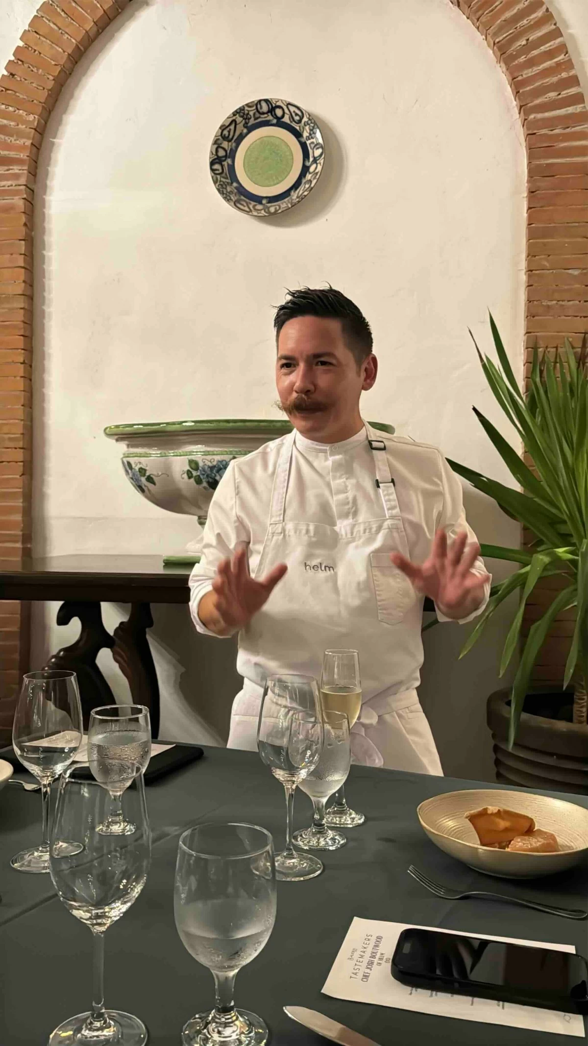 CHEF AT WORK Chef Josh Boutwood explains the evening’s courses during the one-night-only tasting dinner at Toscana Village.