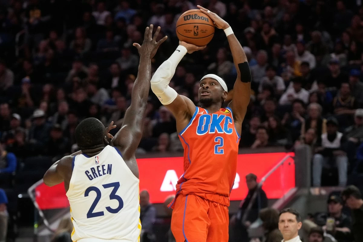 Oklahoma City Thunder guard Shai Gilgeous-Alexander (2) shoots against Golden State Warriors forward Draymond Green (23) during the second half of an NBA basketball game in San Francisco, Tuesday, Dec. 2, 2025. (AP Photo/Jeff Chiu)