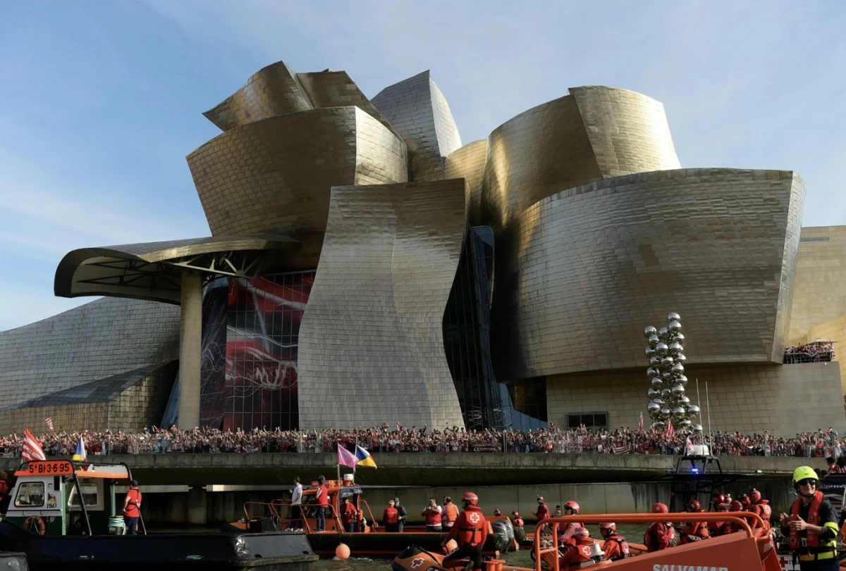 Athletic Bilbao fans wait in front of the Guggenheim museum as support boats pass before team celebrations on the Nervion Estuary in Bilbao, Spain, Thursday, April 11, 2024. (AP Photo/Alvaro Barrientos, File)
