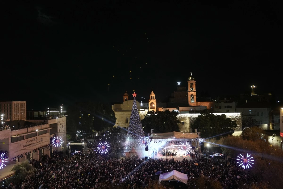 Palestinians take part in a Christmas tree–lighting event in Manger Square, next to the Church of the Nativity, traditionally regarded as the birthplace of Jesus Christ ahead of Christmas in the West Bank city of Bethlehem Saturday, Dec. 6, 2025. (AP Photo/Mahmoud Illean)