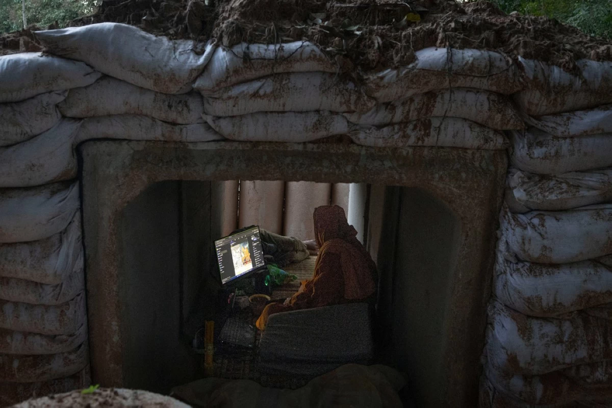 A Thai Buddhist monk uses his computer while taking shelter in Buriram province, Thailand, Tuesday, Dec. 9, 2025, after he fled clashes between Thai and Cambodian soldiers. (AP Photo/Wason Wanichakorn)