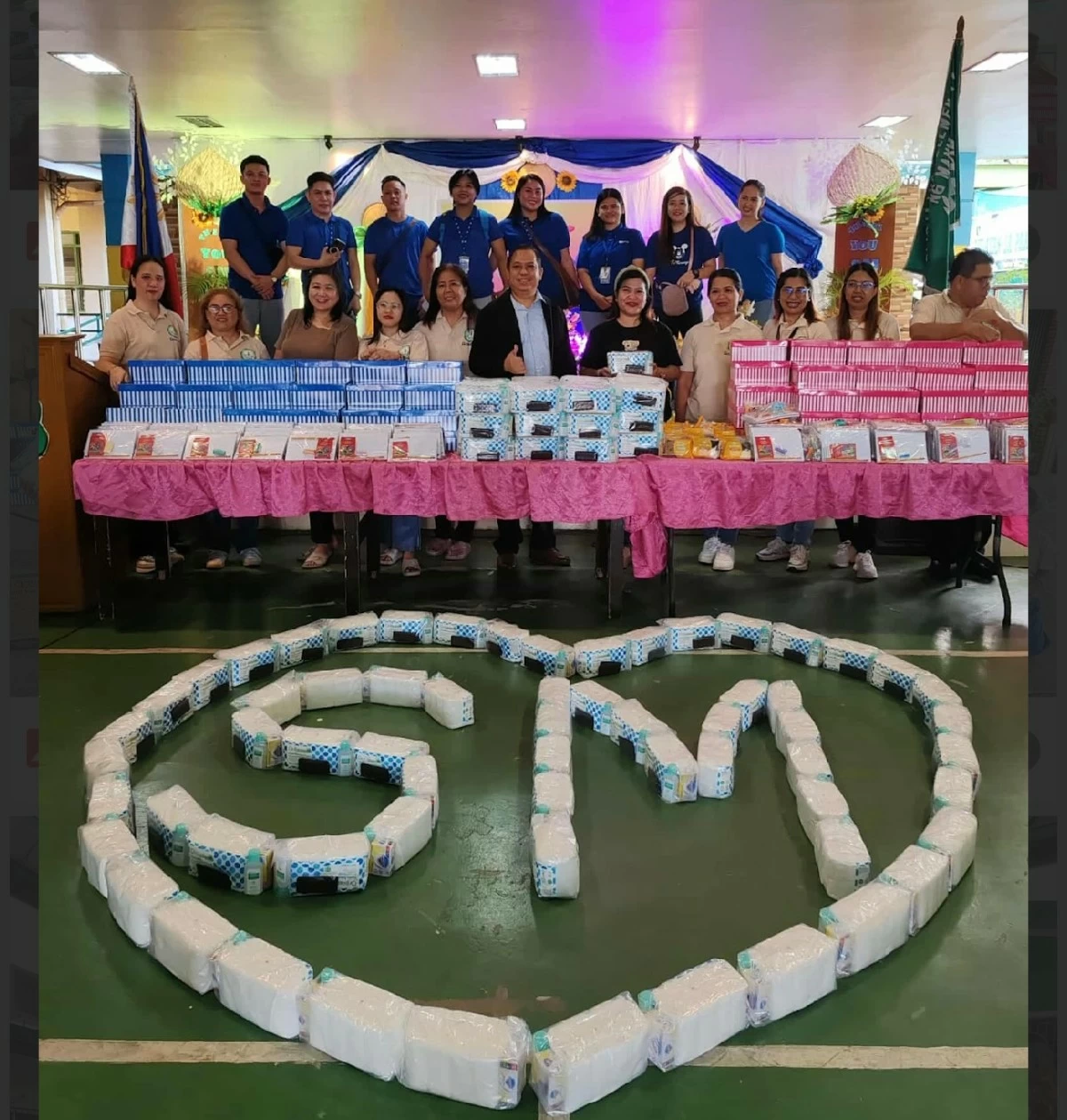Care Kits in the foreground, as arranged by the children; and the boxes of shoes on the table. SM Store and SM Foundation at a beneficiary public school. 