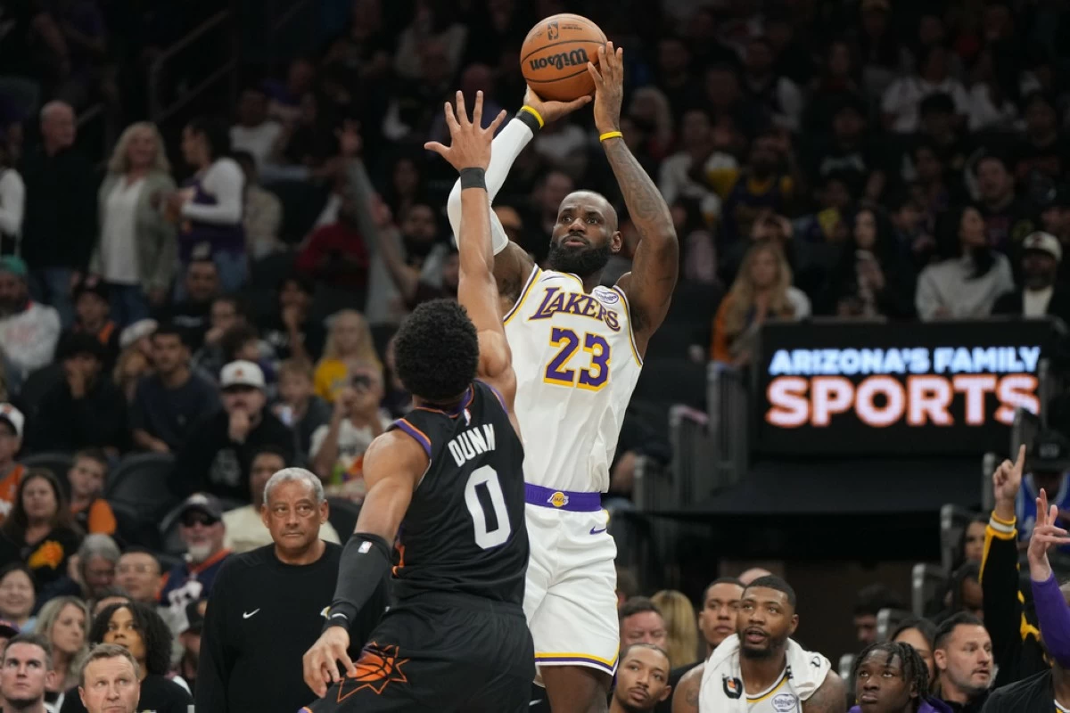 Los Angeles Lakers forward Lebron James (23) looks to shoot over Phoenix Suns forward Ryan Dunn (0) during the first half of an NBA basketball game, Sunday, Dec. 14, 2025, in Phoenix. (AP Photo/Rick Scuteri)