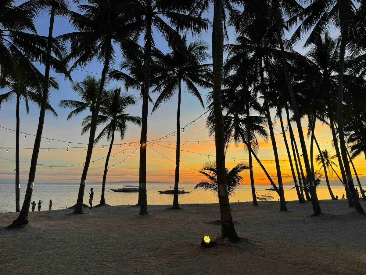 TWILIGHT CALM The serene beach of South Palms Panglao as day slips into twilight, with soft light settling over the sand and sea at the close of another island afternoon