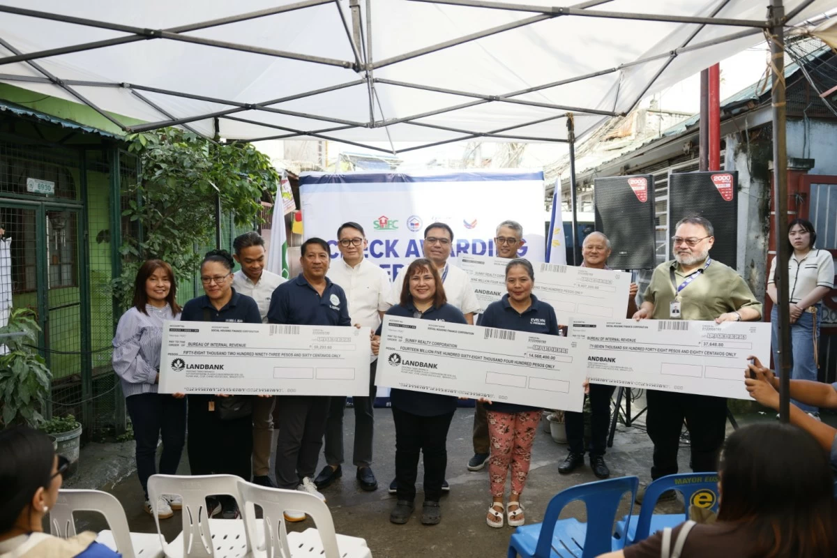 
DHSUD Secretary Jose Ramon Aliling and SHFC president and chief executive officer Federico Laxa turn over the checks for P23 million assistance for the land acquisition in Pasig City that will benefit 237 families. (photo: DHSUD)
