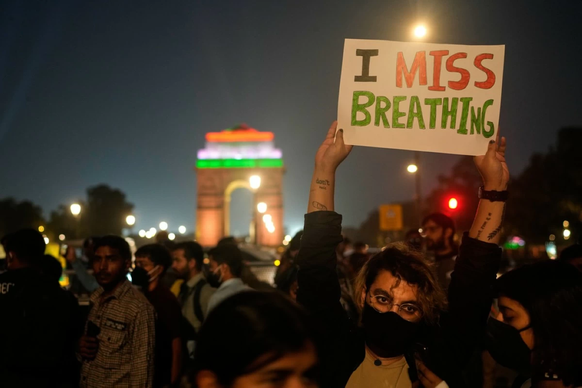 FILE - A person holds a sign during a protest against what they called the government's lack of action to combat air pollution in New Delhi, India, Nov. 9, 2025. (AP Photo/Manish Swarup, File)