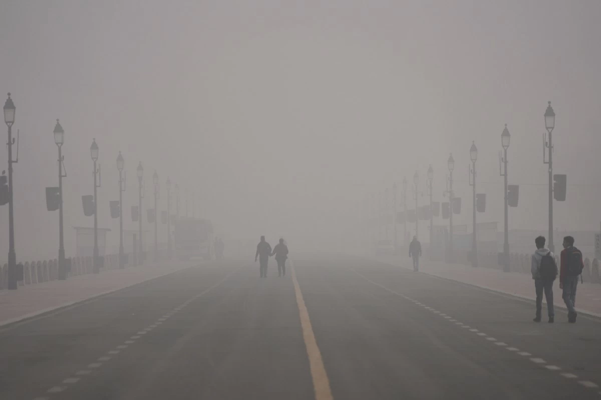 FILE - People walk through smog in New Delhi, India, Dec. 15, 2025. (AP Photo/Piyush Nagpal, File)