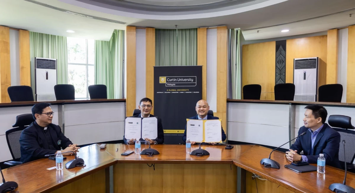 Dean Ladao (second from left) and prof. Lee (third from left) hold up their signed memoranda