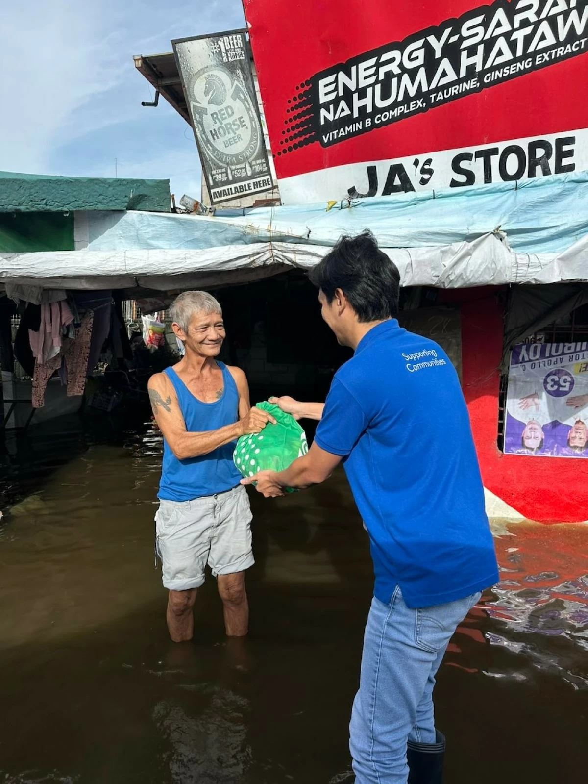 Inspired by the immediate, ready commitment shown by leaders like Regional Operations Head Andrea Rodriguez, an SM employee-volunteer pushes through flooded alleys in Pampanga to deliver essential relief.