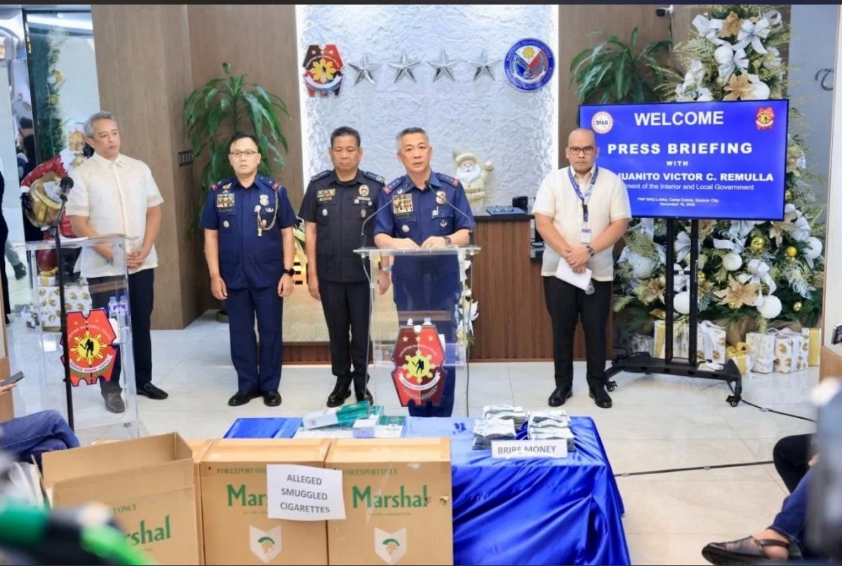 Acting PNP chief Lt. Gen. Jose Melencio C. Nartatez, Jr. presents cases of smuggled cigarettes that were part of the P143 million worth of contraband seized in an operation in Quezon City on Dec. 17, 2025. Also in the photo are DILG Secretary Jonvic Remulla and HPG director Brig. gen. Hansel Marantan. (photo: PNP)