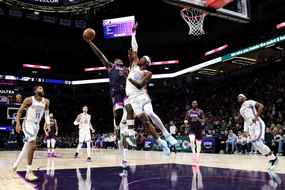Minnesota Timberwolves guard Anthony Edwards (5) goes up for a shot as Oklahoma City Thunder guard Shai Gilgeous-Alexander defends during the first half of an NBA basketball game, Friday, Dec. 19, 2025, in Minneapolis. (AP Photo/Matt Krohn)