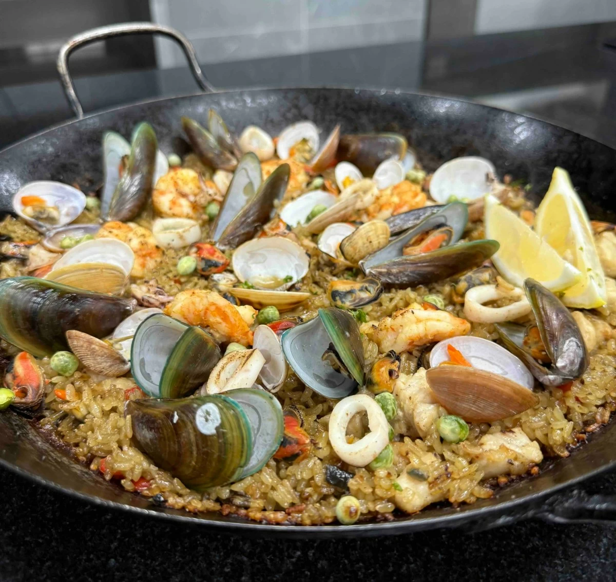 SEAFOOD CENTERPIECE Seafood paella by Chef Jester Garcia Arellano, made with saffron-infused rice, shrimp, squid, mussels and clams, designed for Noche Buena sharing.