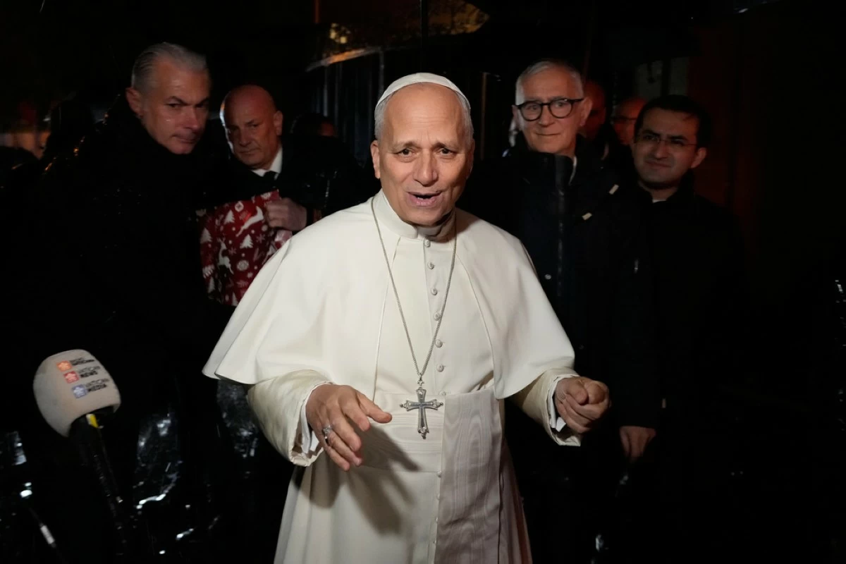 Pope Leo XIV talks to journalists as he leaves the Castel Gandolfo residence to head to the Vatican, Tuesday, Dec. 23, 2025. (AP Photo/Gregorio Borgia)