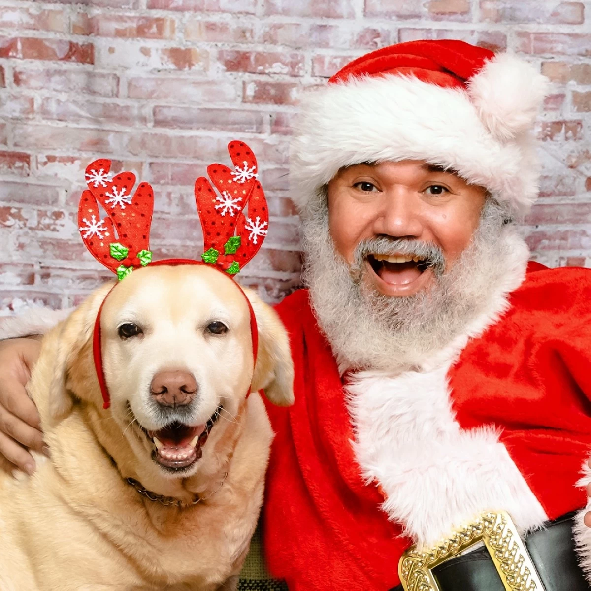 HOLIDAY DUO — Louie Aguinaldo in his Santa Claus costume with his dog, Sunlight, wearing reindeer ears.