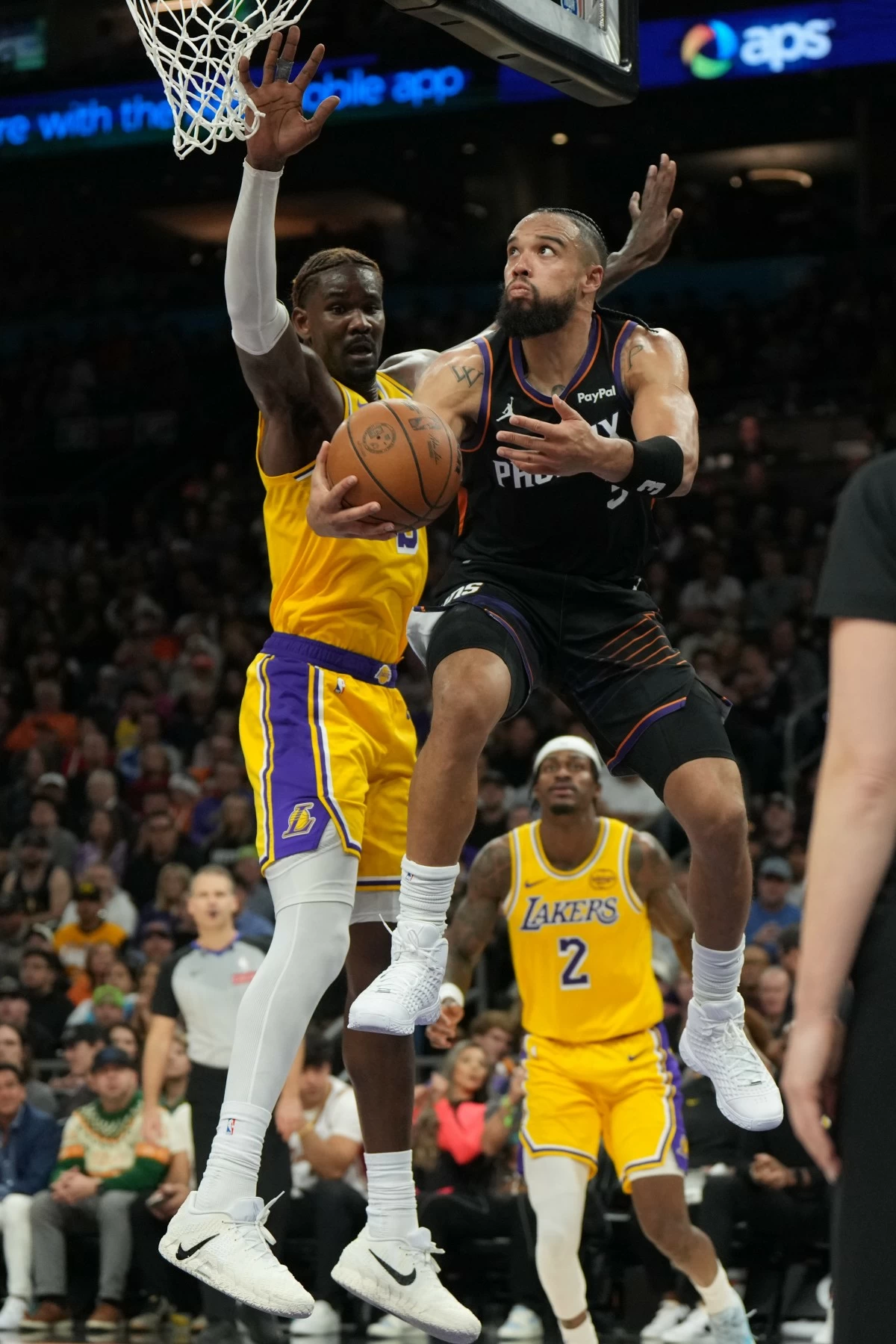 Phoenix Suns forward Dillon Brooks scores on Los Angeles Lakers center Deandre Ayton (5) during the second half of an NBA basketball game, Tuesday, Dec. 23, 2025, in Phoenix. (AP Photo/Rick Scuteri)