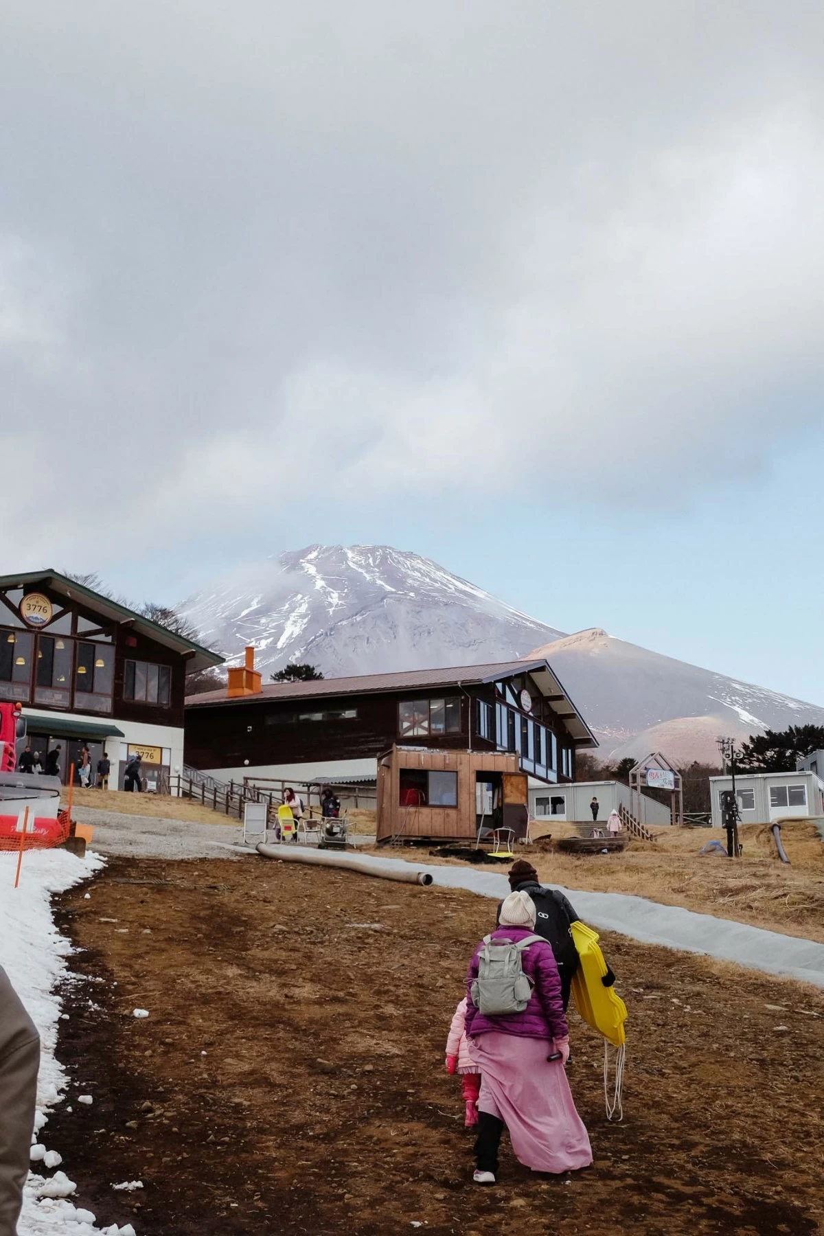 A FAMILY WALKS at a ski resort at the foot of Mt. Fuji (at the background).