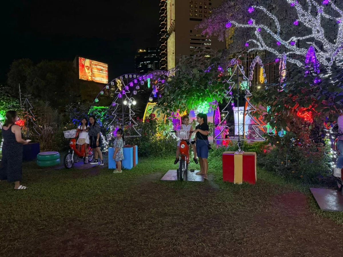 Children pedal stationary bikes to generate power for a Christmas tree. This year’s Liwanag Park emphasizes sustainability by integrating renewable energy themes and displays crafted from recyclable materials.