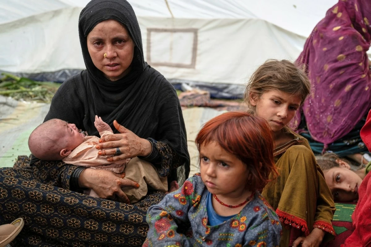 FILE - A woman and her children, survivors of Sunday night's 6.0-magnitude earthquake, wait for assistance in the village of Wadir, Kunar province, eastern Afghanistan, Tuesday, Sept. 2, 2025. (AP Photo/Nava Jamshidi, File)
