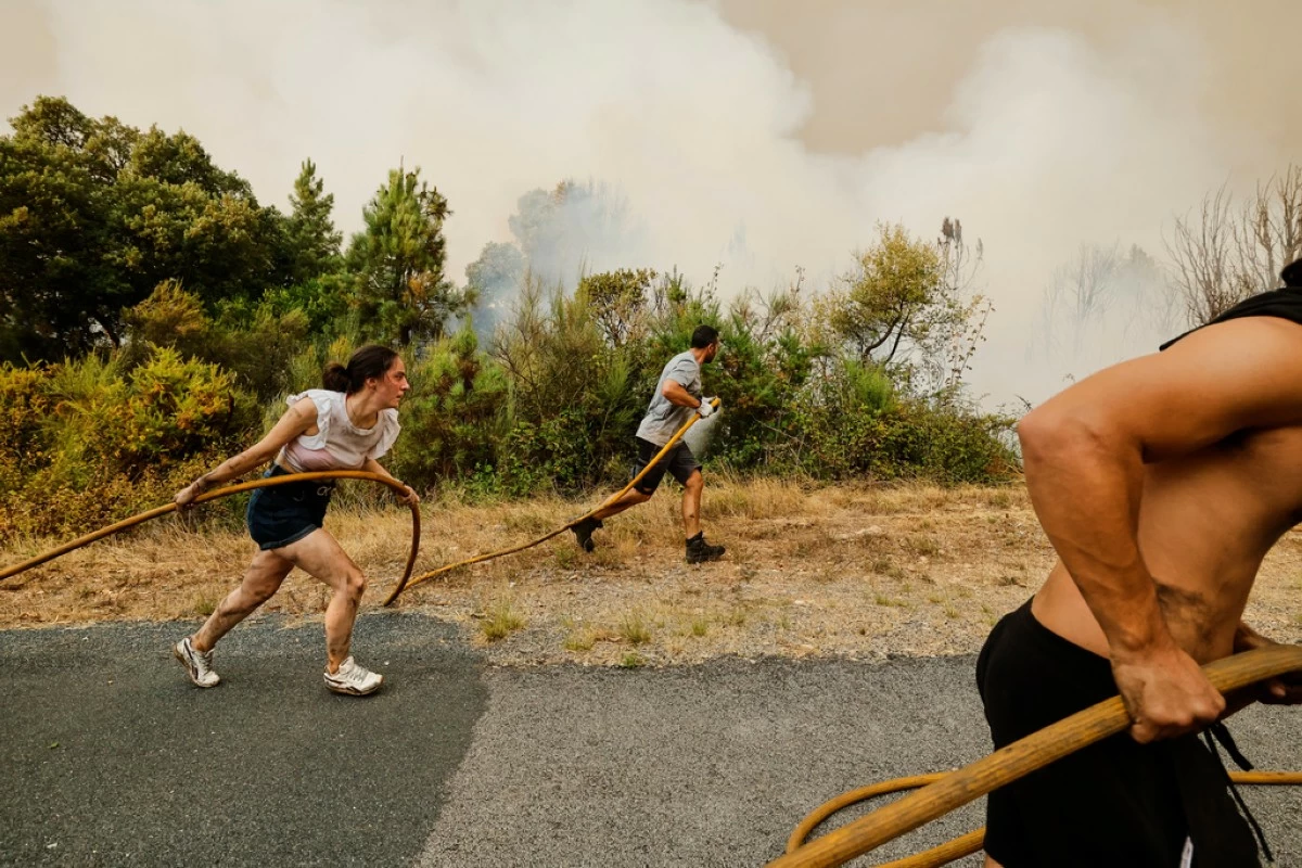 Local residents and volunteers work together to battle an encroaching wildfire in Larouco, northwestern Spain, Aug. 13, 2025. (AP Photo/Lalo R. Villar, File)
