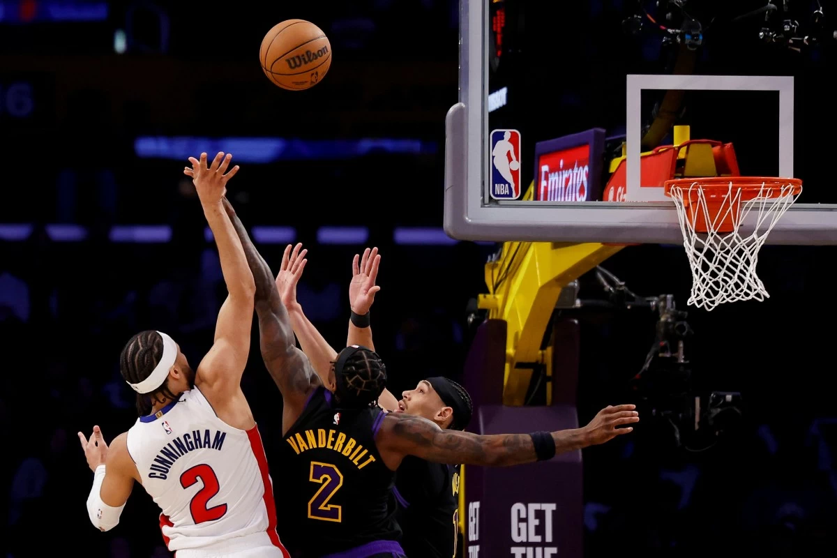 Detroit Pistons guard Cade Cunningham, left, shoots while being guarded by Los Angeles Lakers forward Jarred Vanderbilt, center, and center Jaxson Hayes, right, during the second half of an NBA basketball game Tuesday, Dec. 30, 2025, in Los Angeles. (AP Photo/Caroline Brehman)