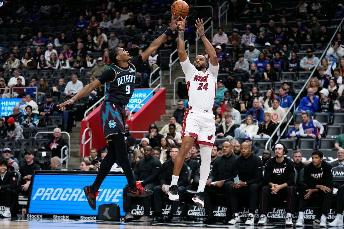 Miami Heat guard Norman Powell, right, shoots against Detroit Pistons guard Ausar Thompson during the first half of an NBA basketball game Thursday, Jan. 1, 2026, in Detroit. (AP Photo/Ryan Sun)