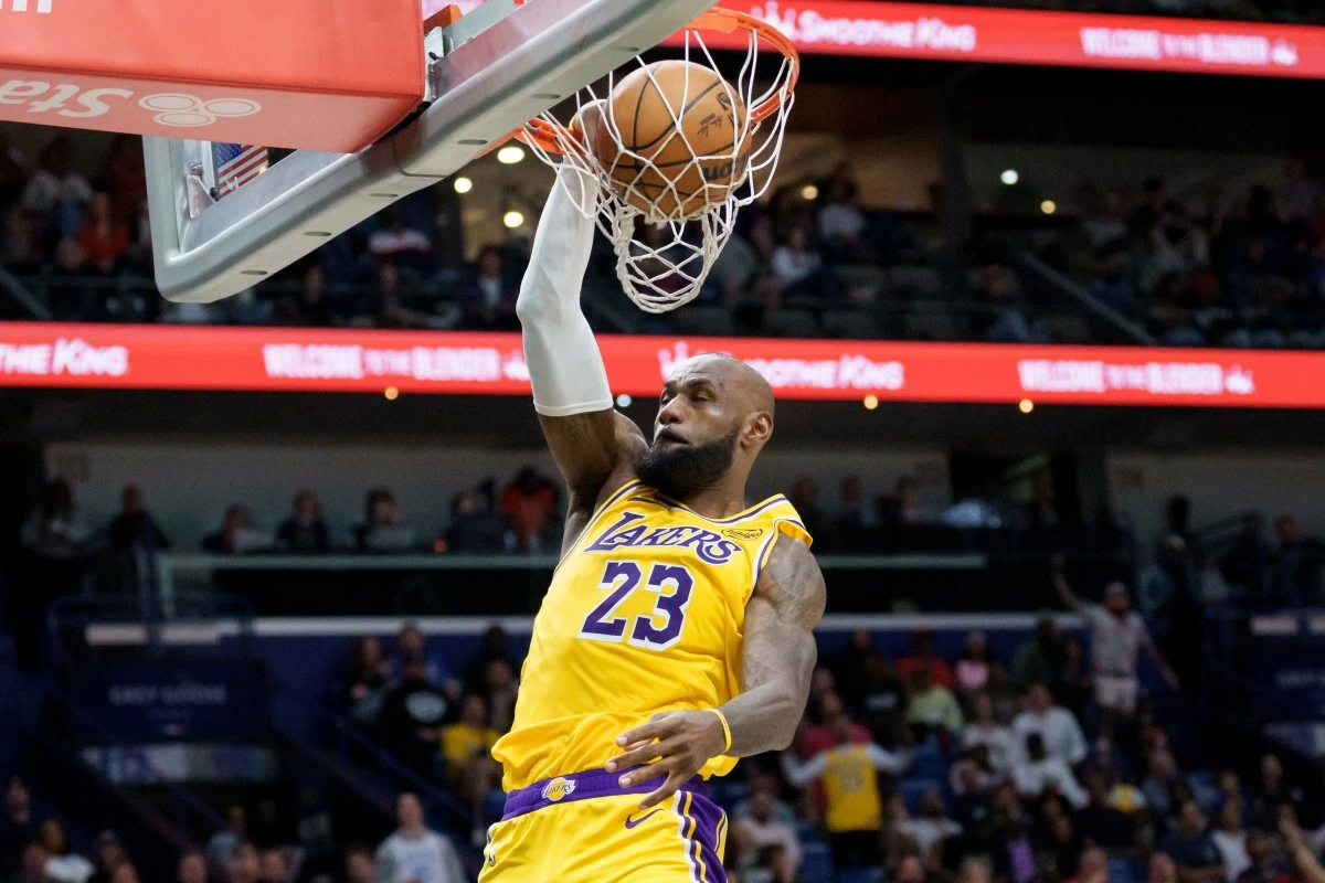 Los Angeles Lakers forward LeBron James (23) breaks free for a dunk against the New Orleans Pelicans during the second half of an NBA basketball game in New Orleans, Tuesday, Jan. 6, 2026. (AP Photo/Matthew Hinton)