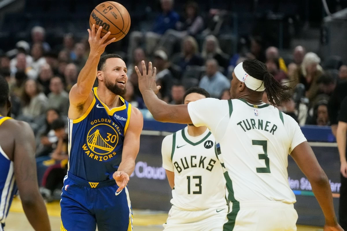 Golden State Warriors guard Stephen Curry (30) shoots against Milwaukee Bucks guard Ryan Rollins (13) and center Myles Turner (3) during the second half of an NBA basketball game in San Francisco, Wednesday, Jan. 7, 2026. (AP Photo/Jeff Chiu)