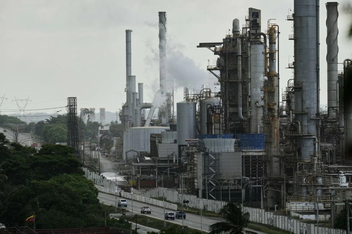 FILE - Vehicles drive past the El Palito  oil refinery in Puerto Cabello, Venezuela, Dec. 21, 2025. (AP Photo/Matias Delacroix, File)