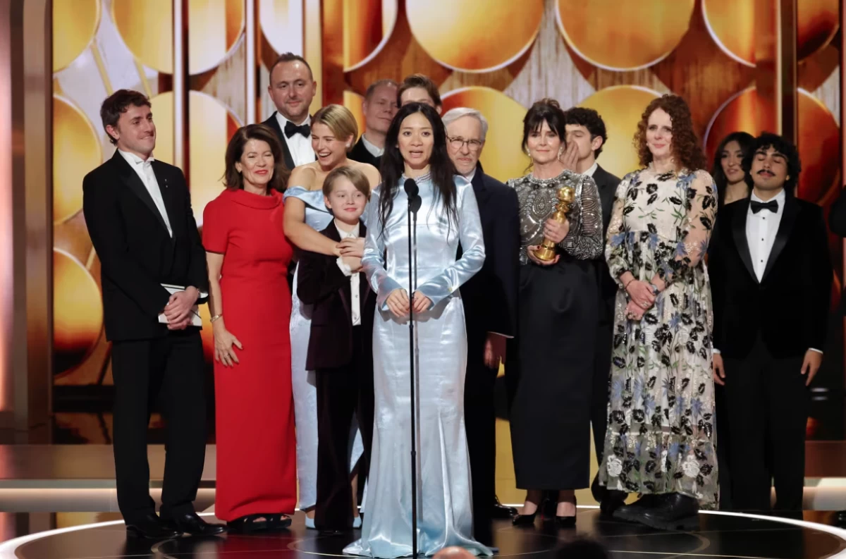 Chloé Zhao (center) gives an acceptance speech for best motion picture for the film 'Hamnet.'