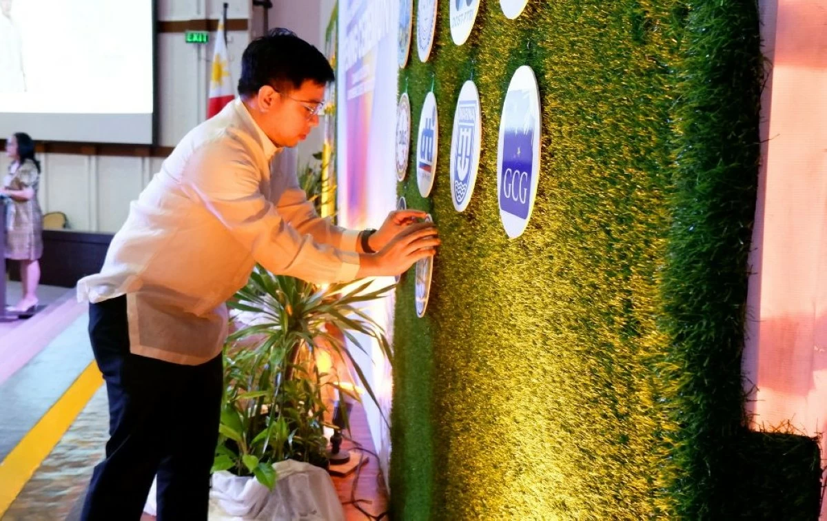An MMC Batch 37 scholar mounts his agency logo on the ceremonial board during the Rite of Inclusion (Carla Bauto Deña/MANILA BULLETIN)