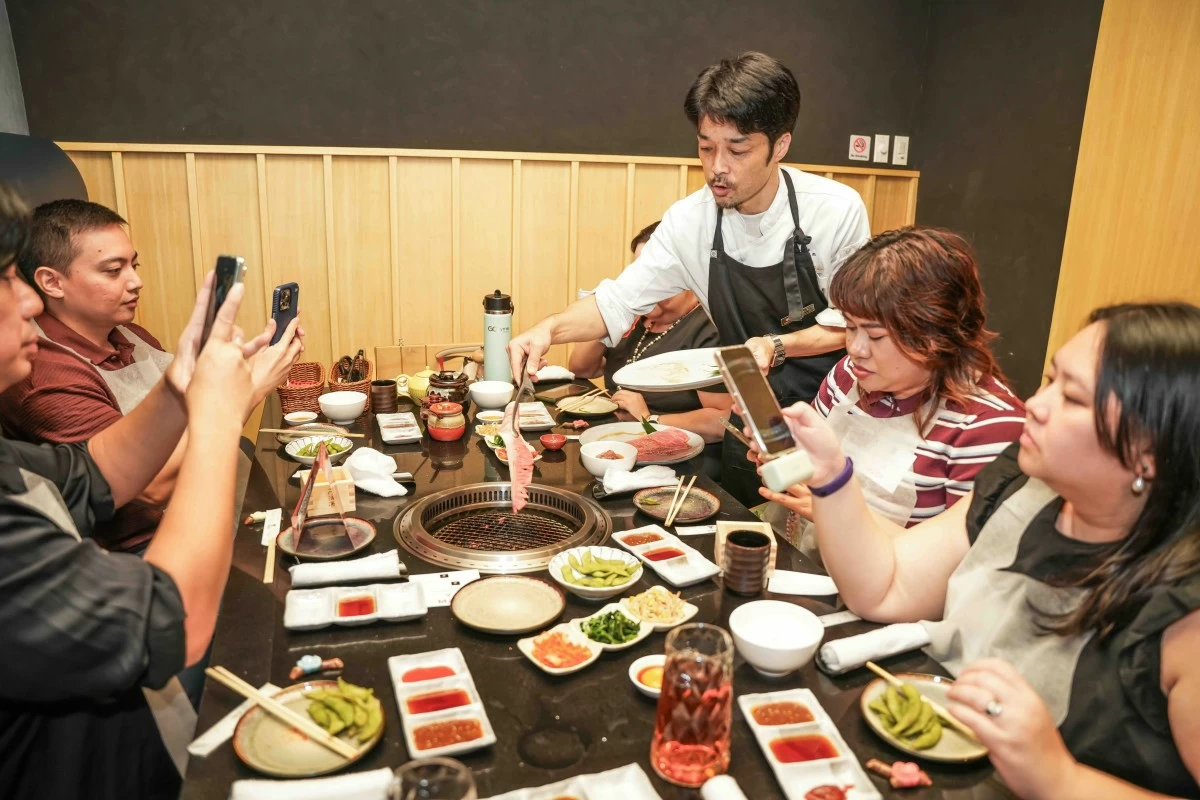 BEHIND THE SCENES The author, alongside fellow media guests, documents the opening as Hiro staff present premium wagyu beef