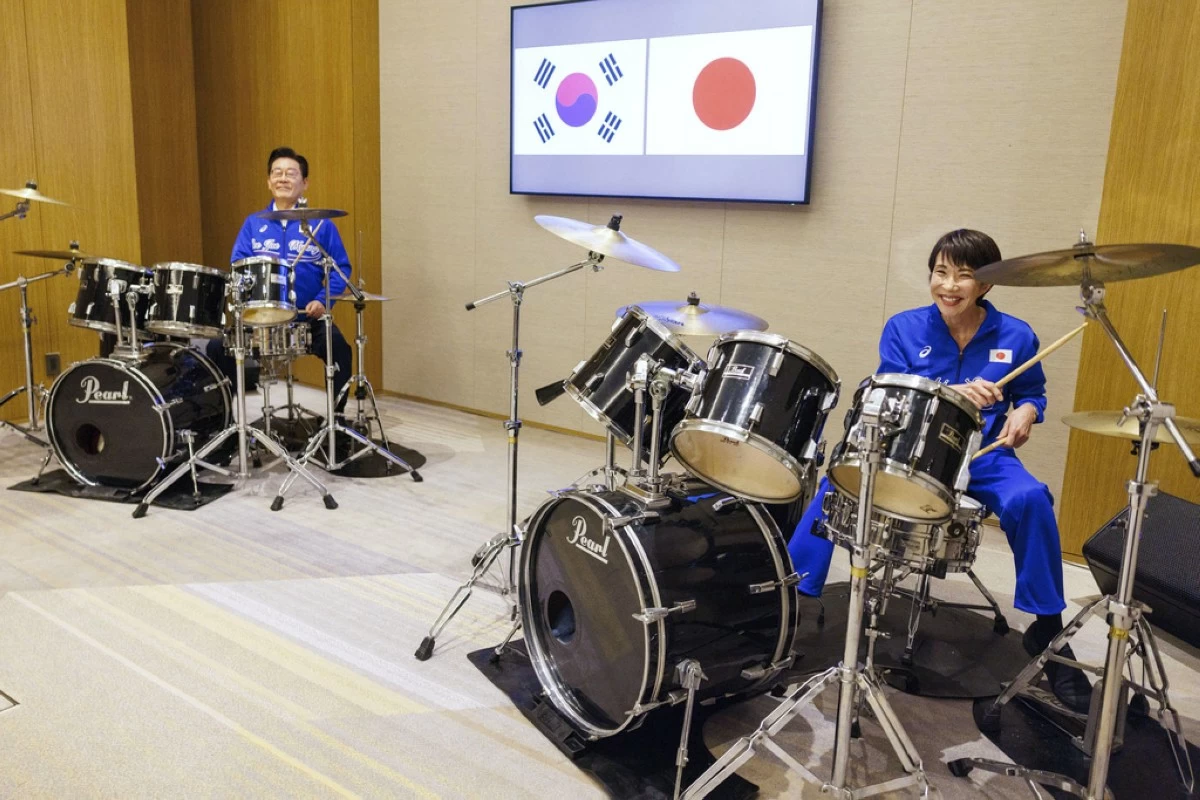 In this photo released on the official website of Prime Minister's Office of Japan, Japanese Prime Minister Sanae Takaichi, right, and South Korean President Lee Jae Myung play drump together after their talks in Nara, western Japan Tuesday, Jan. 13, 2026.  (Prime Minister's Office of Japan via AP)