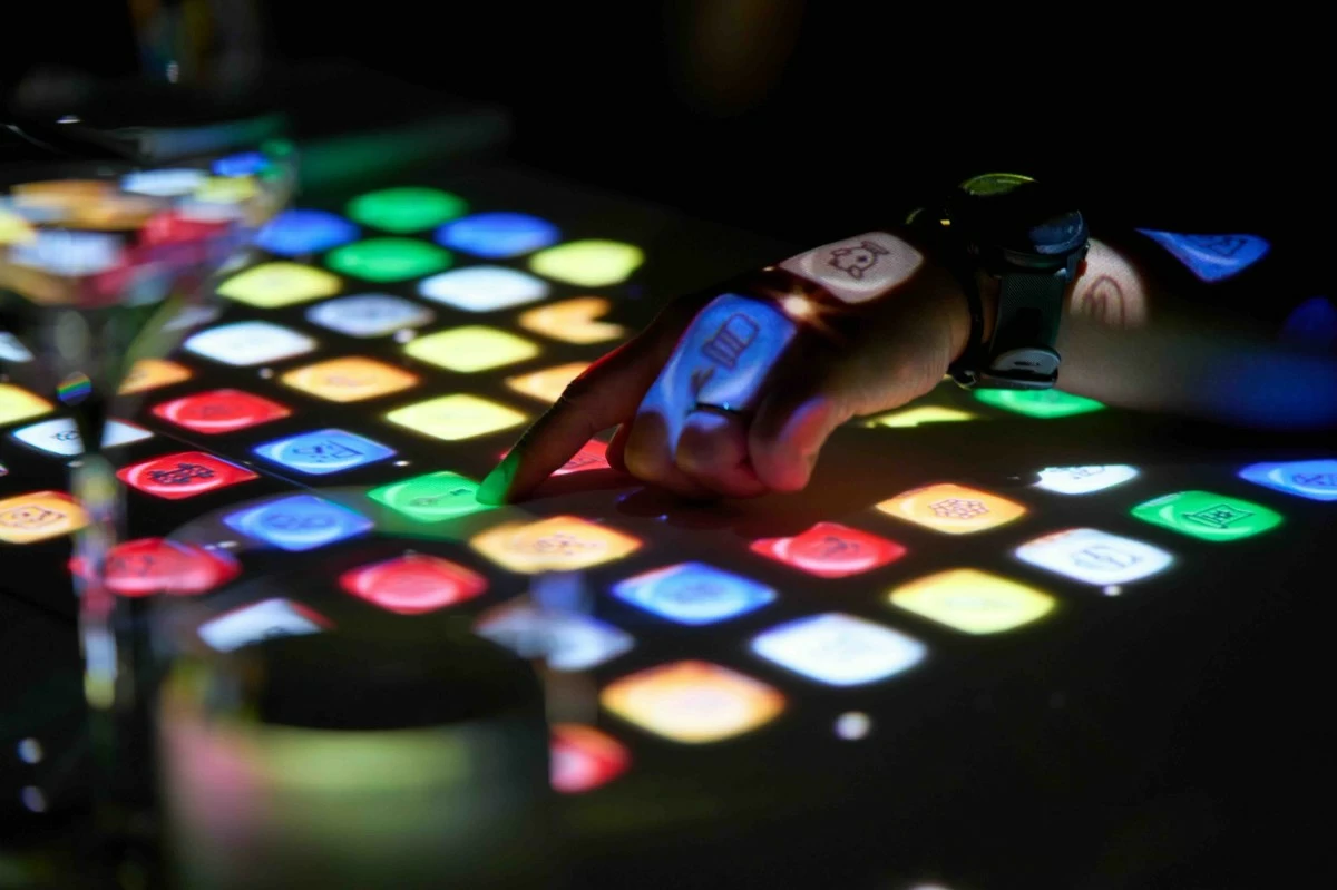 MIND GAMES An illusion sequence unfolds across the projection-mapped table, prompting diners to follow instructions, test their memory, and watch the impossible resolve itself in plain sight.