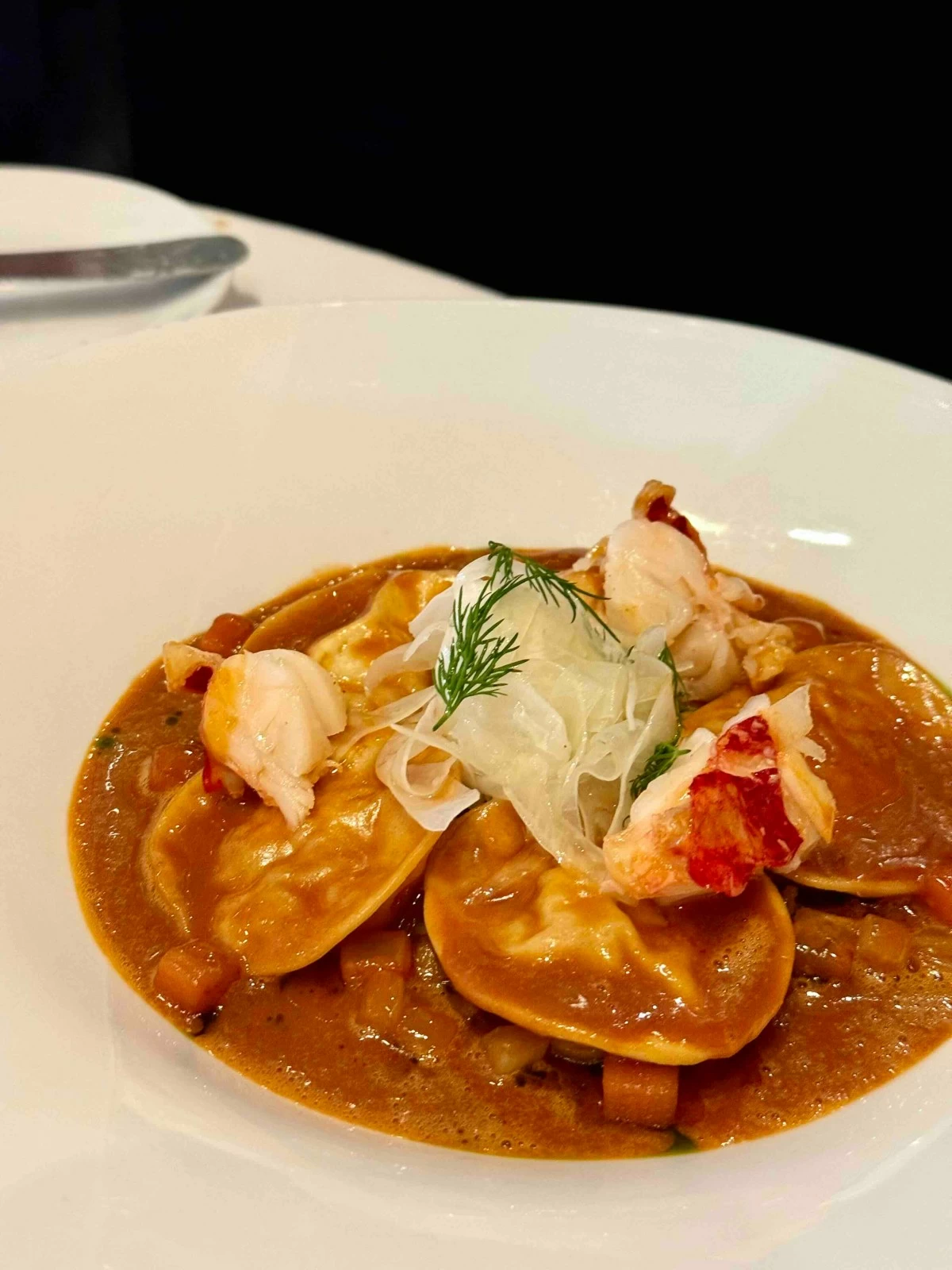 BISQUE ENCASED  Breton lobster ravioli in a rich bisque, lifted by candied fennel and lemon.