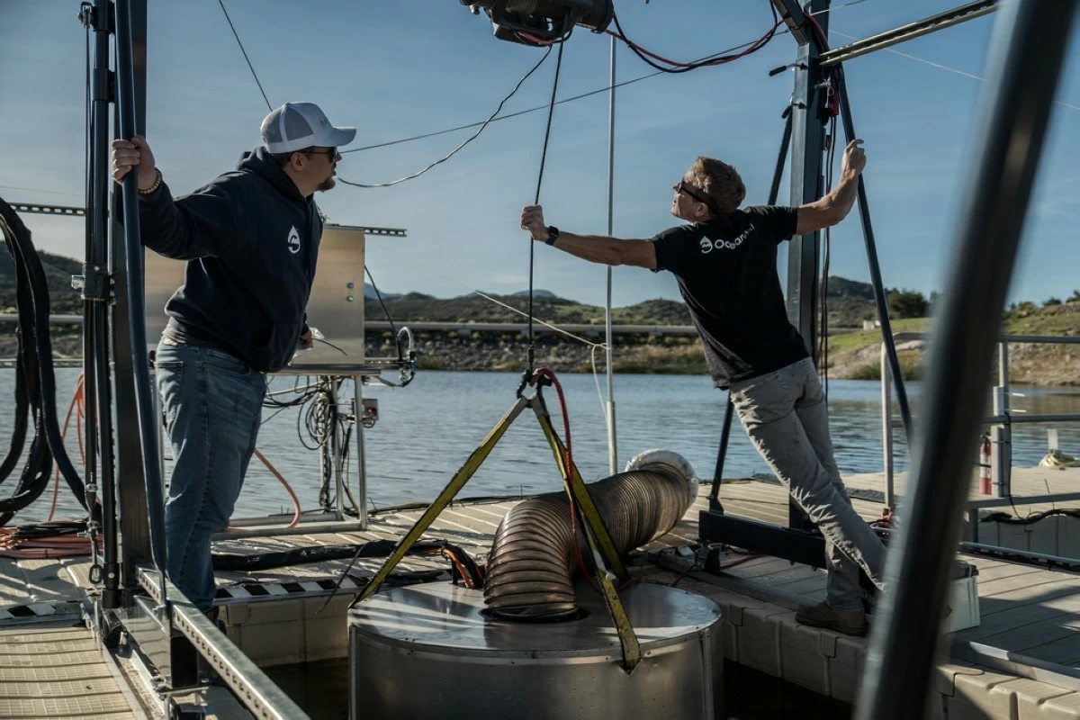 Jaden Gilliam, OceanWell project engineer, left, and Mark Golay, director of engineering projects, lower a prototype reverse osmosis pod into Las Virgenes Reservoir in Westlake Village, Calif., Monday, Dec. 1, 2025. (AP Photo/Annika Hammerschlag)