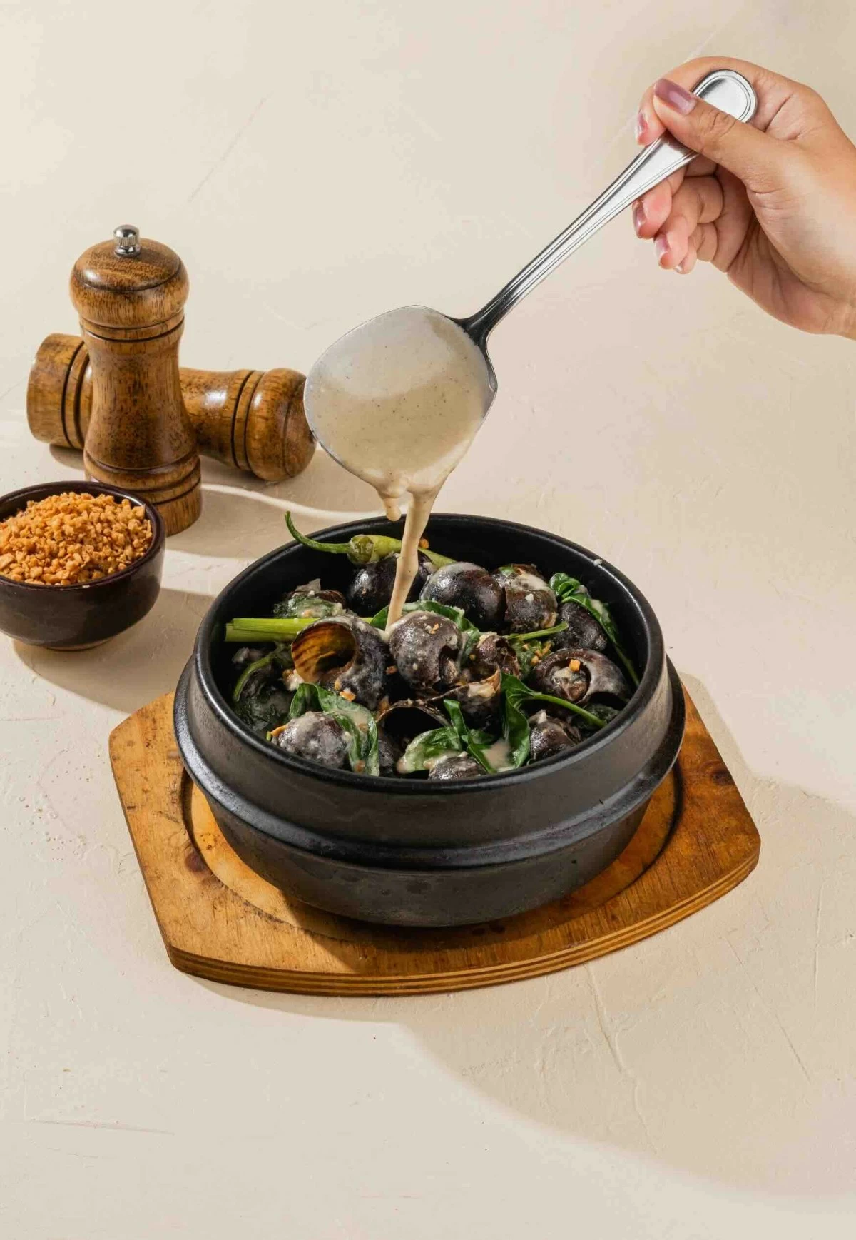 SLOW SIMMER Kuhol ni Tanggol, cooked in a rich, deeply savory sauce, served as a leisurely, hands-on start to the meal.