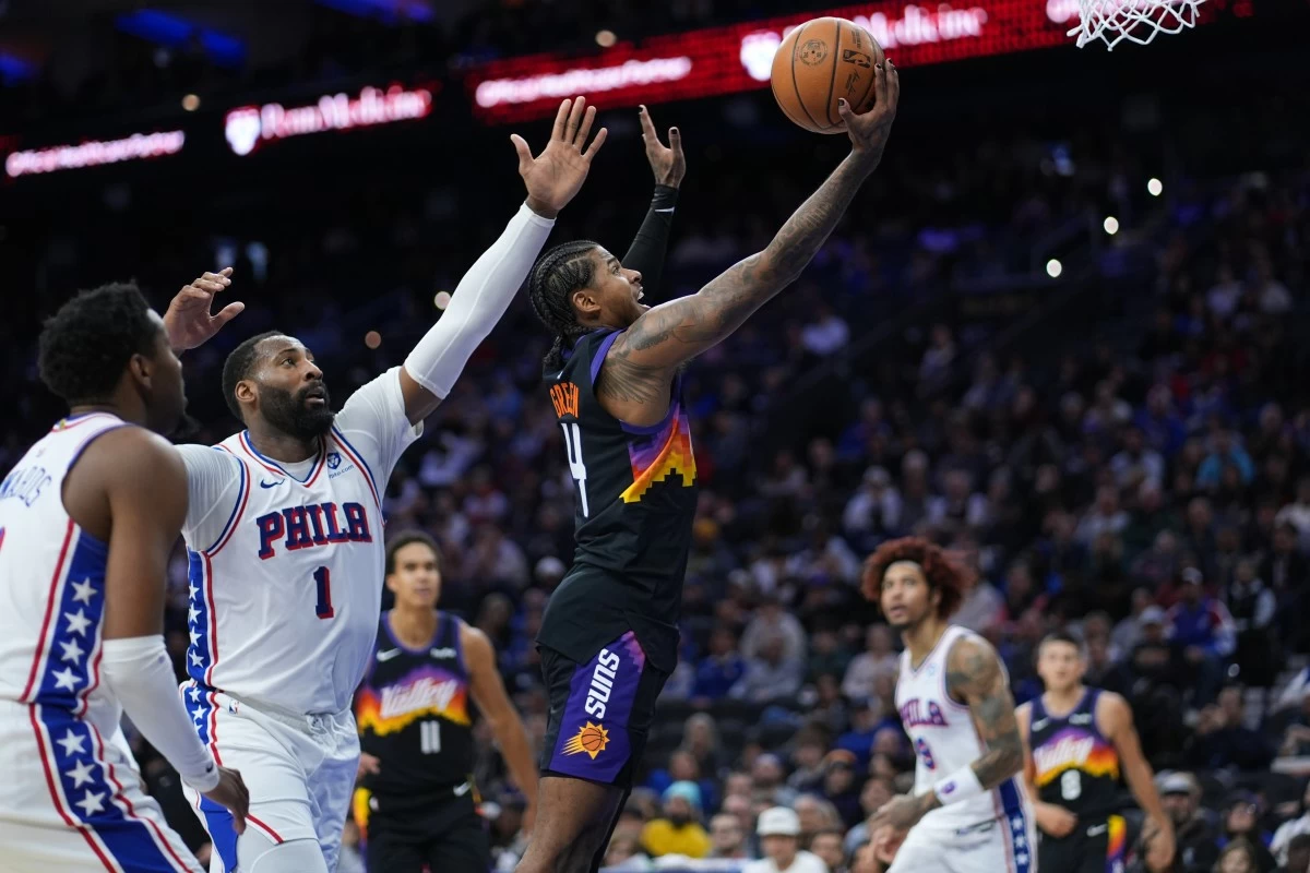 Phoenix Suns' Jalen Green, right, goes up for a shot against Philadelphia 76ers' Andre Drummond during the first half of an NBA basketball game Tuesday, Jan. 20, 2026, in Philadelphia. (AP Photo/Matt Slocum)