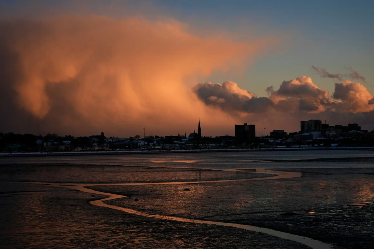 Storm clouds that had brought brief snow flurries begin to clear, Tuesday, Jan. 20, 2026, over Portland, Maine. (AP Photo/Robert F. Bukaty)