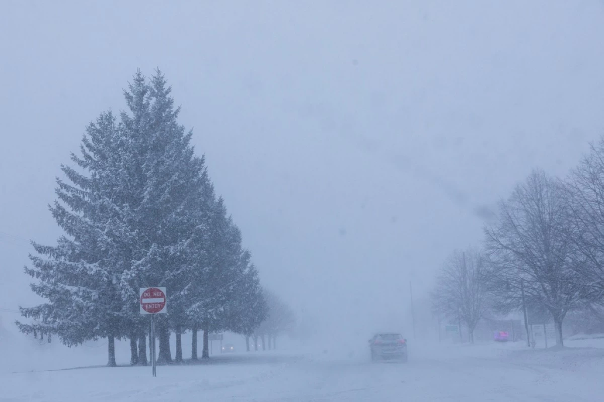 Vehicles are driven through whiteout conditions along Lake Michigan Drive during a winter storm warning in Ottawa County, Mich. on Monday, Jan. 19, 2026. (Joel Bissell/Kalamazoo Gazette via AP)