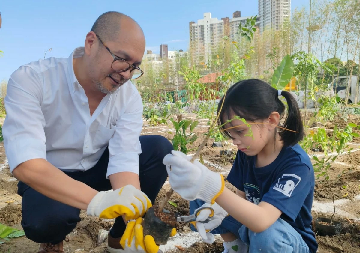 Hans Lopez-Vito, Ayala Land vice president and head of Brand Experience and Strategy - Residential Business Group, Estates, and Corporate of Ayala Land, Inc., and a Multiple Intelligence International School student plant a tree at the Eco Forest.         