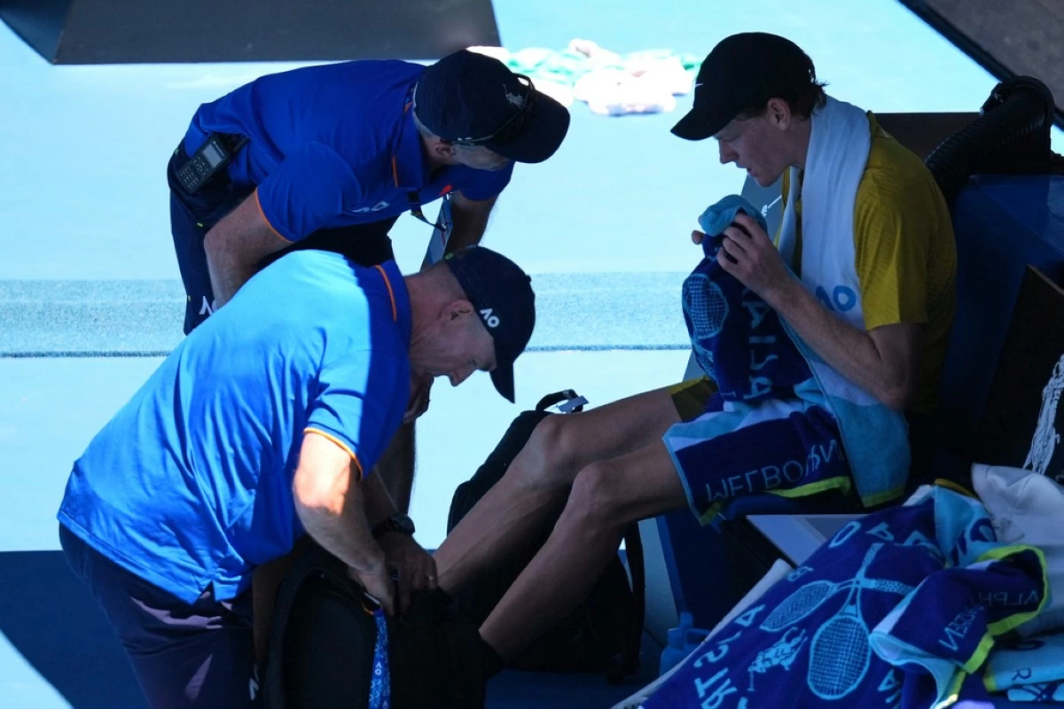 Jannik Sinner of Italy receives treatment from trainers during his third round match against Eliot Spizzirri of the U.S.at the Australian Open tennis championship in Melbourne, Australia, Saturday, Jan. 24, 2026. (AP Photo/Dita Alangkara)