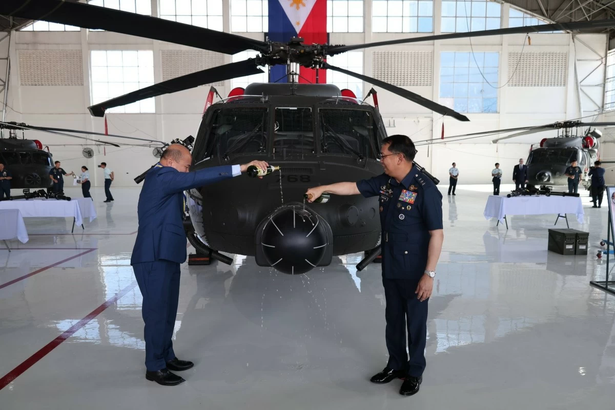 (L-R) Acting Department of Budget and Management (DBM) Secretary Rolando U. Toledo and Philippine Air Force (PAF) Commanding General Lt. Gen. Arthur M. Cordura pour champagne on one of the five newly acquired S70-i Black Hawk helicopters as a traditional aviation blessing and acceptance ritual during a ceremony at the Colonel Jesus Villamor Air Base in Pasay City on January 23, 2026. (Photo: PAF)