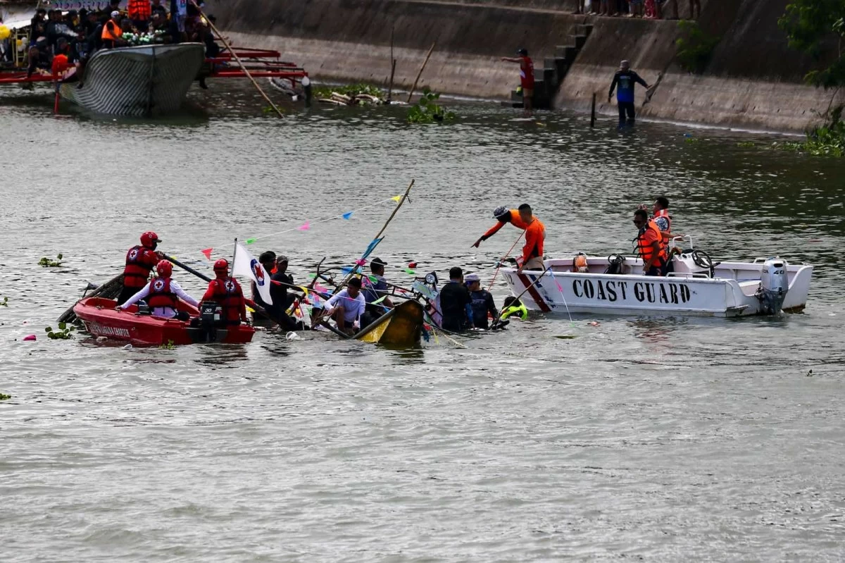 AUTHORITIES rescue passengers of a sunken boat during a fluvial procession in Laguna on Sunday. (John Louie Abrina) 