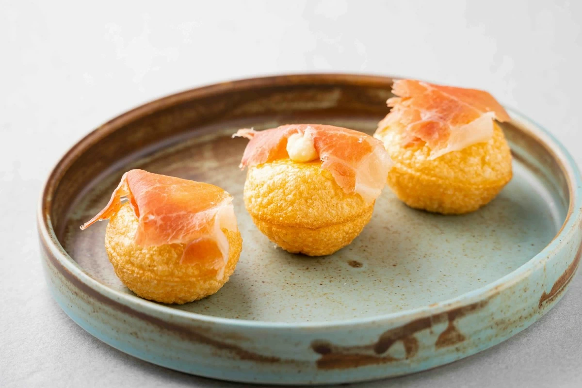 JAMON BITE The Jamon Explosion pairs manchego mousse with crisp puffed bread