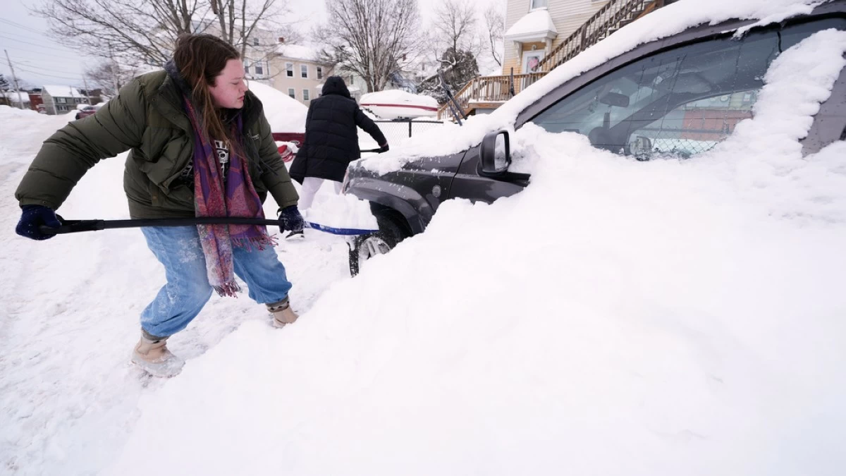 Emma Teske shovels out her car following a winter storm that dumped more than a foot and a half of snow across the region, Tuesday, Jan. 27, 2026, in Haverhill, Mass. (AP Photo/Charles Krupa)