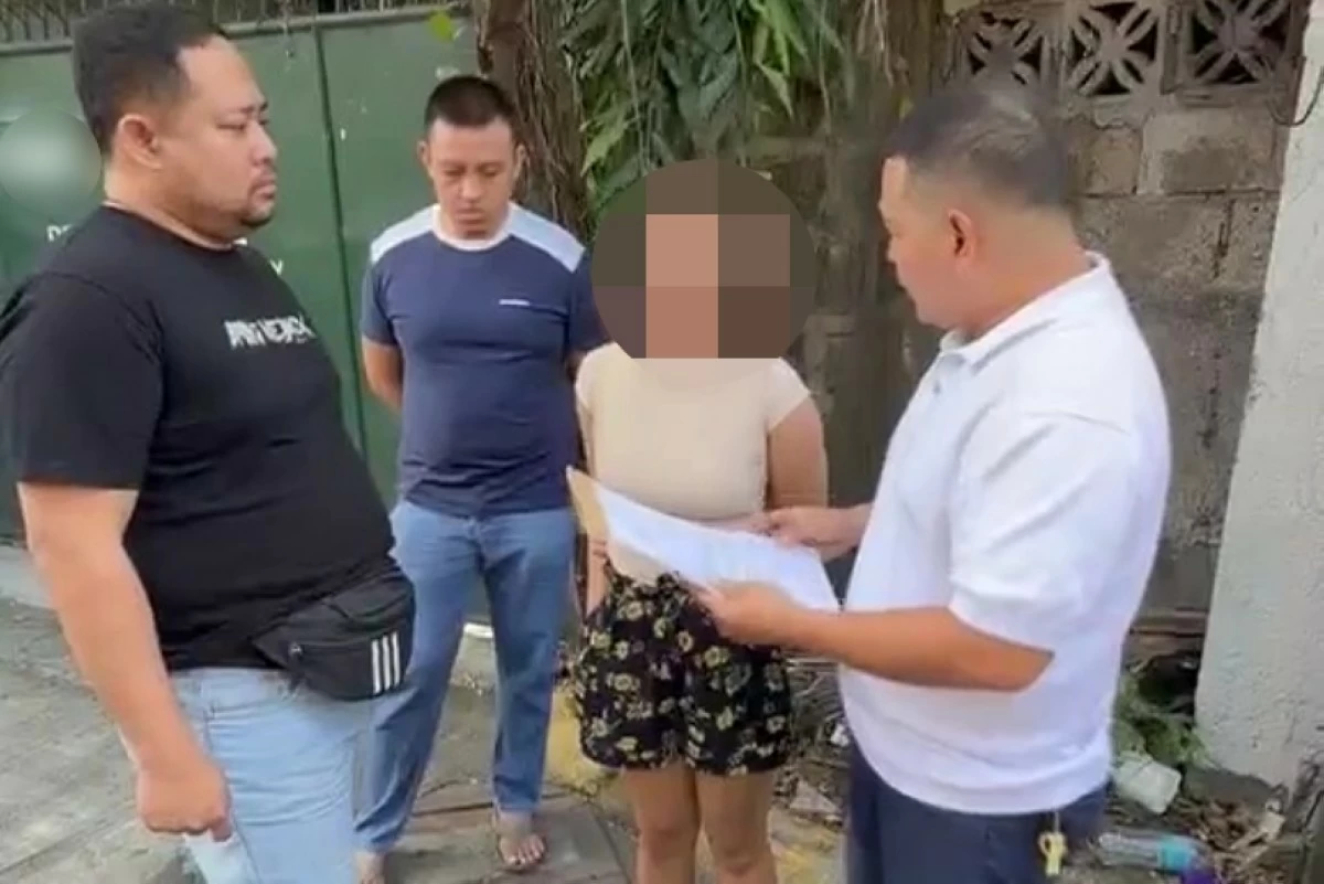 Taguig police officers serve a warrant of arrest on the woman convicted by a court in a drug case (Screenshot from Taguig police's video) 