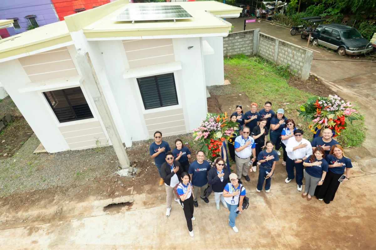 Lhoopa team members and Pag-IBIG Fund officials pose beside green housing units at Townhill Tanay, equipped with rooftop solar panels, rainwater catchment systems, and efficient insulation, glass, and shading to improve efficiency and support household resilience.