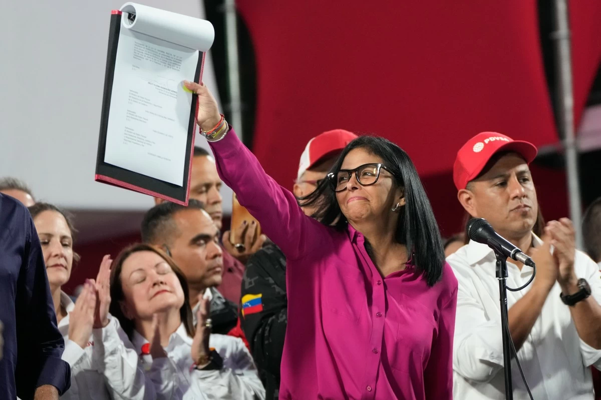 Venezuela's acting President Delcy Rodriguez takes part in a rally holding up a copy of a new law after lawmakers approved legislation opening the nation's oil sector to privatization, at the Miraflores Palace in Caracas, Venezuela, Thursday, Jan. 29, 2026. (AP Photo/Ariana Cubillos)