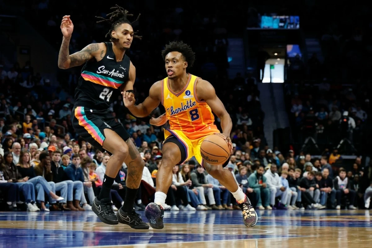 Charlotte Hornets guard Collin Sexton (8) drives against San Antonio Spurs guard Devin Vassell during the second half of an NBA basketball game in Charlotte, N.C., Saturday, Jan. 31, 2026. (AP Photo/Nell Redmond)