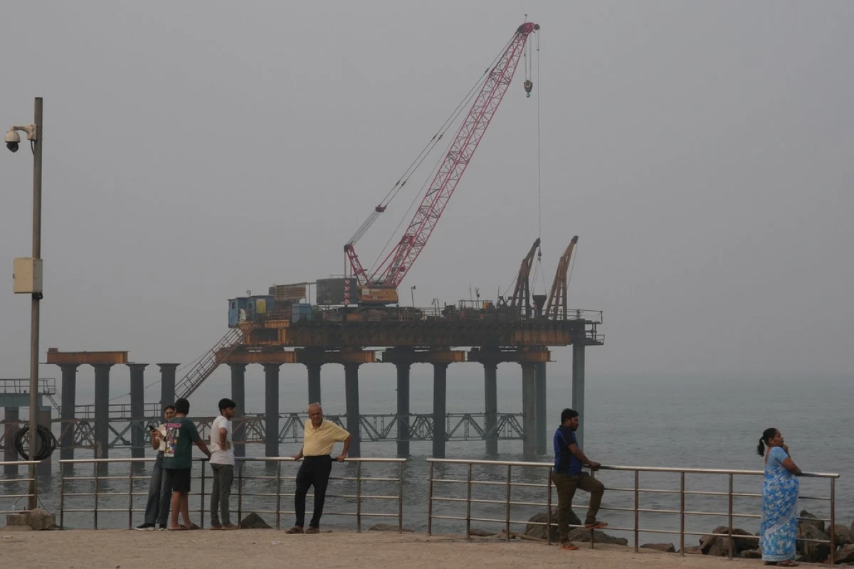 People stand near the site of the under-construction coastal road in Mumbai, India, Sunday, Feb. 1, 2026. (AP Photo/Rafiq Maqbool)